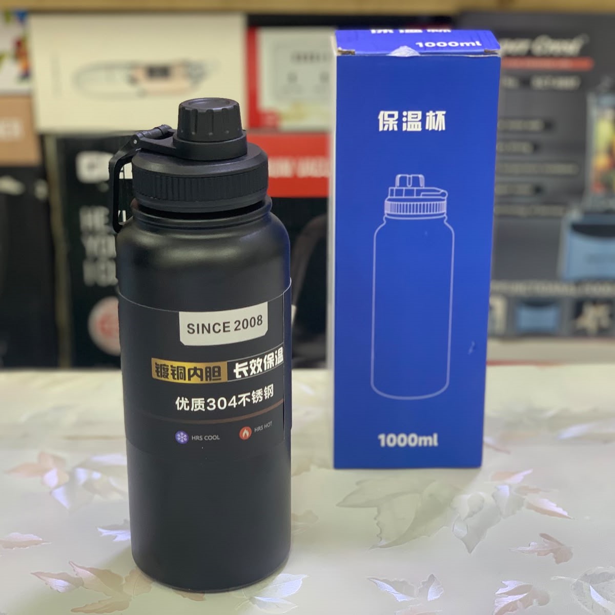 Durable 1000ml vacuum insulated stainless steel bottle keeps drinks hot or cold with carrying strap.